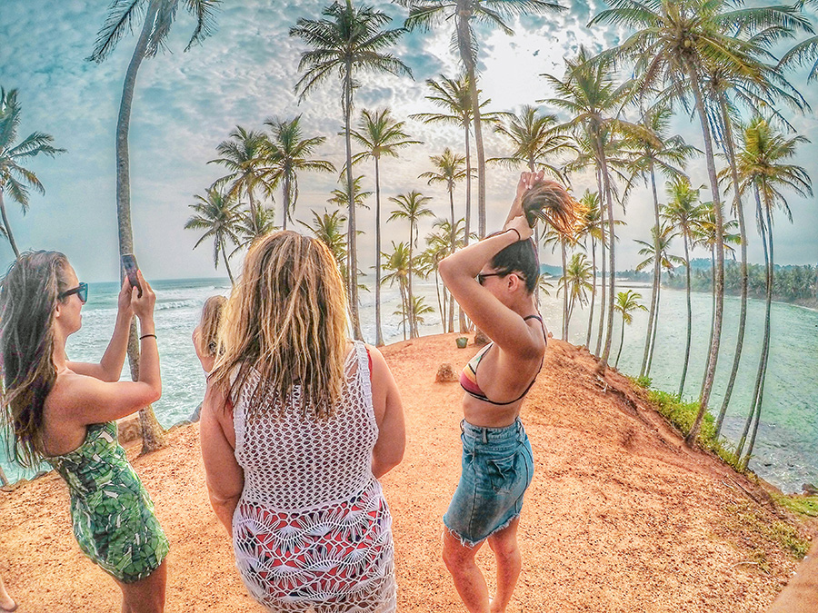 Three girls at a beach along with Palm trees