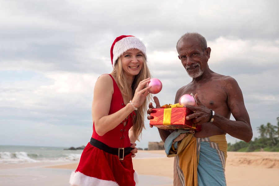 A foreign girl dressed as Santa giving a gift box to a Sri Lankan man revealing the Delight of the Blissful Christmas in Sri Lanka!