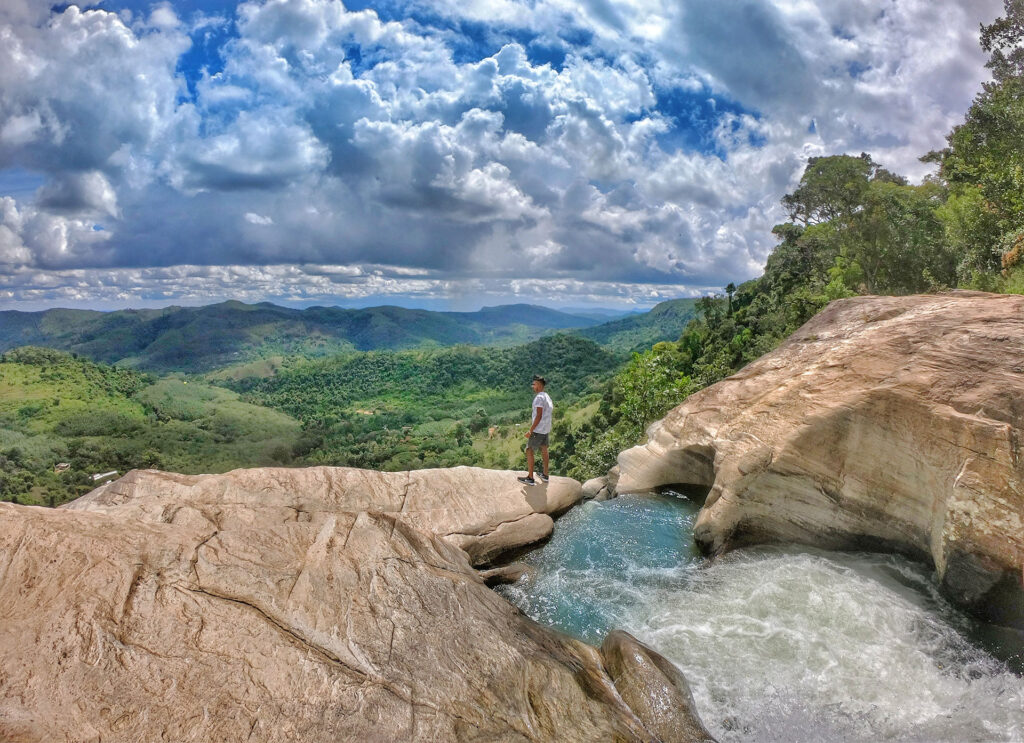 A man standing on the rocky terrains of the camping site of Diyaluma Waterfall