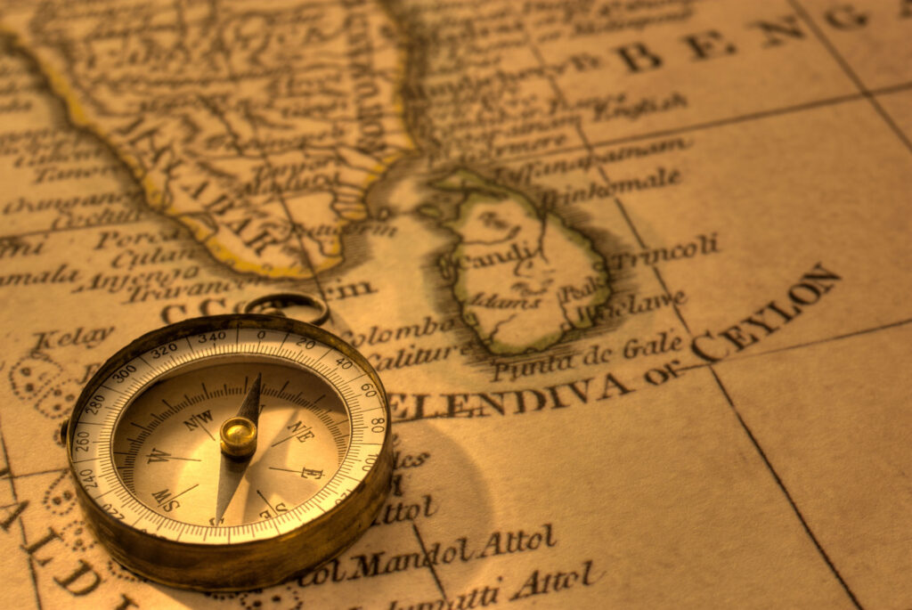 An ancient map featuring South India, and Sri Lanka, along with a compass, signifying the period of Sri Lanka after independence.