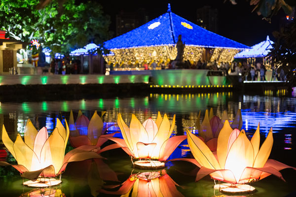 Colourful vesak lanterns in the shape of lotus, floating on lake water signifying the delight of the Vesak Festival in Sri Lanka!