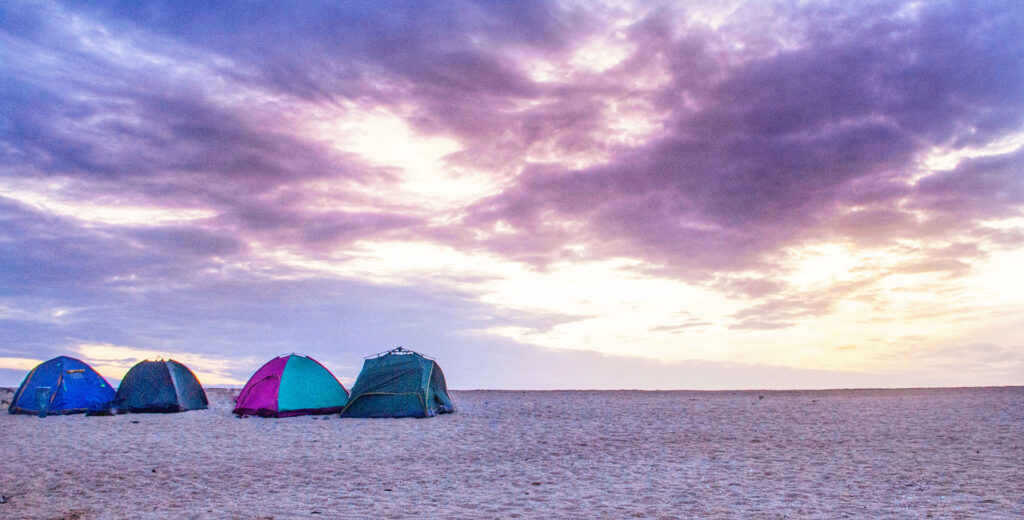 Four colorful camping tents on the beach