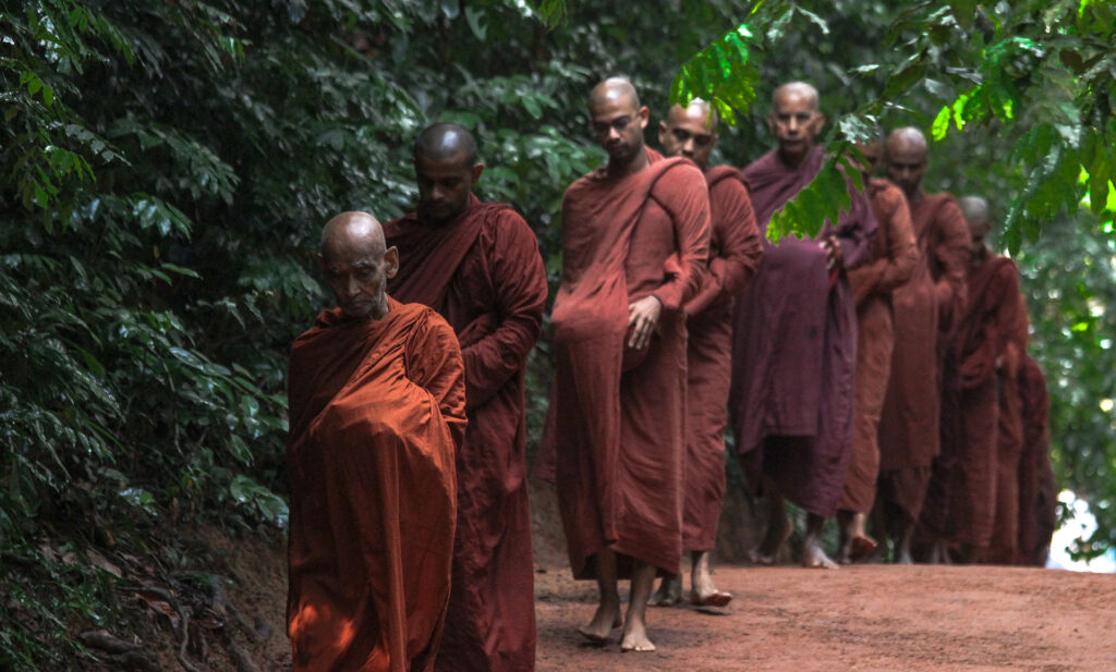 Group of monks walking along a road on a monastery