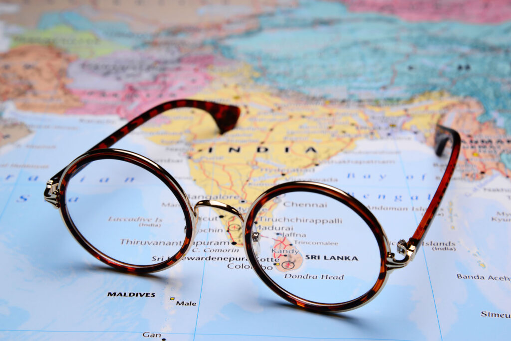 Travel guides in Sri Lanka; a red colour pair of spectacles on a world map