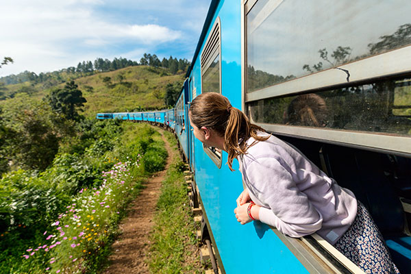 A foreigner peeping through the train window, enjoying the Surroundings during a Kandy to Ella Train Ride
