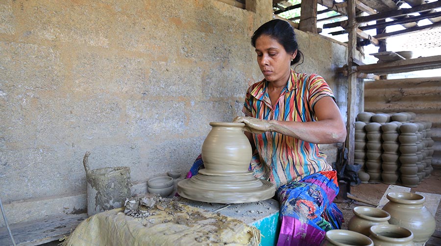 A woman making a pot, signifying the pottery industry in Sri Lanka