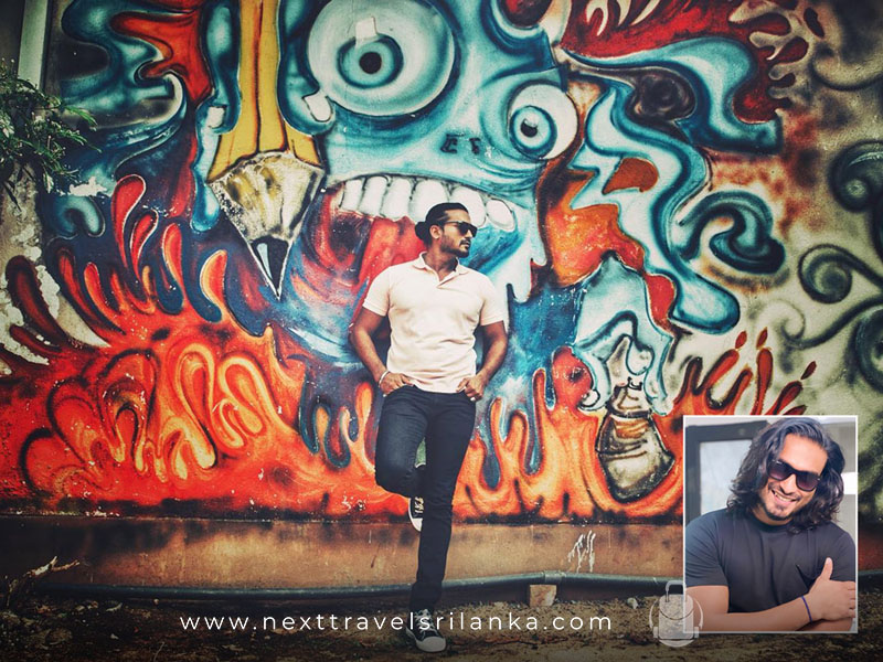 Hemal Ranasinghe, the Wonderful Actor in Sri Lankan Cinema, standing in front of a wall with paintings