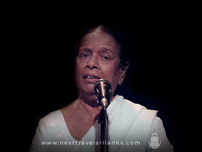 Nanda Malini, the Wonderful Singer from Sri Lanka with a microphone, wearing a white saree