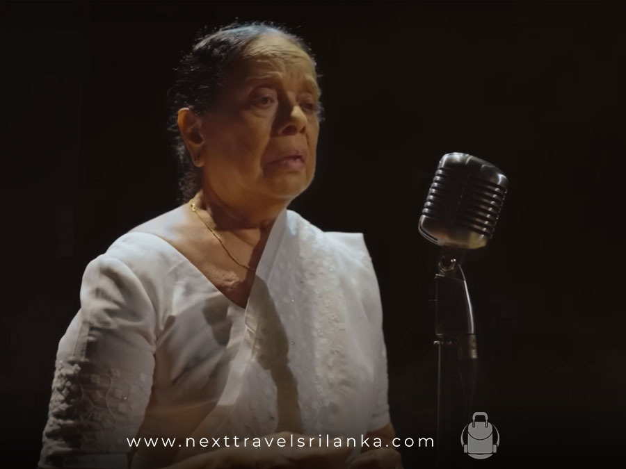 Nanda Malini, the Wonderful Singer from Sri Lanka with a microphone, wearing a white saree